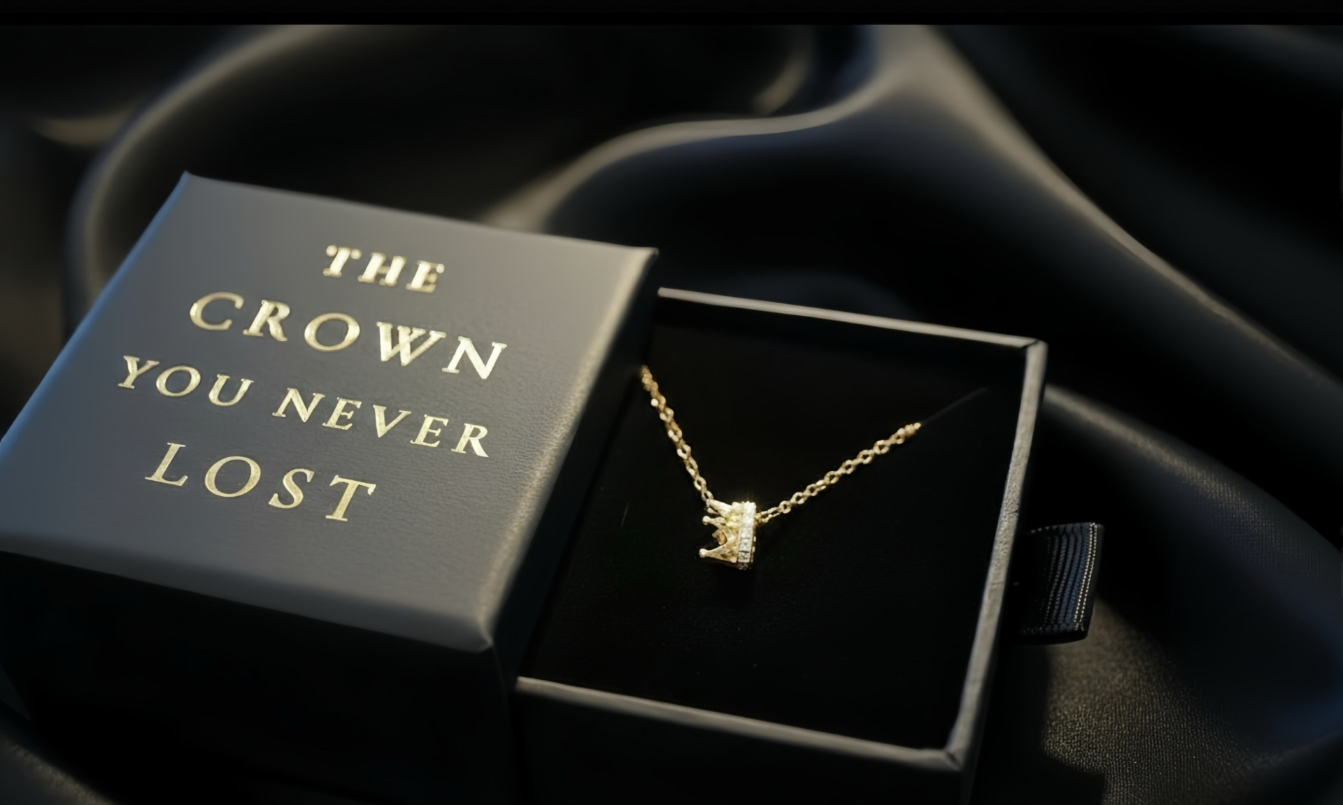 The Crown You Never Lost signature gold pendant in its black and gold gift box